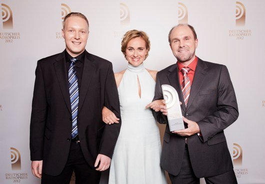 Gemeinsam haben Jens Baumgart (re) und Patrik Buchmüller (li) mit der Sendung "Der Tag in Rheinland-Pfalz" in der Kategorie "Bestes Nachrichtenformat" 2012 den Deutschen Radiopreis gewonnen. Laudatorin Carmen Miosga übergab ihnen die Trophäe.